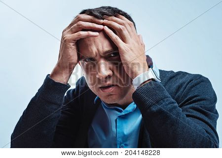 I have no strength. Emotionally exhausted gentleman in smart casual holding his head while hating everything and wanting to take a break.