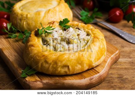 Round meat pie with vegetables and spices on a wooden background. Selective focus.