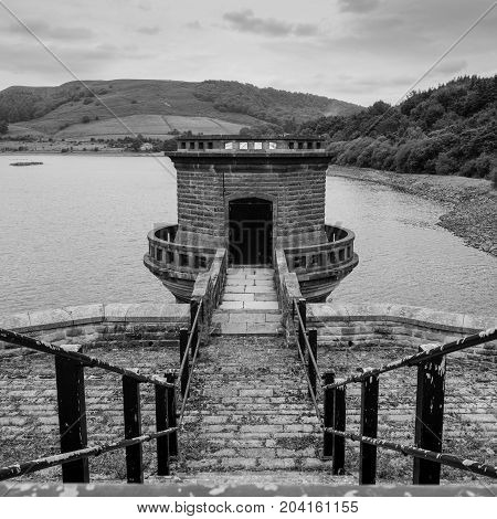 Water Tower Ladybower Reservoir Derbyshire. Steps leading down to water tower. Square crop image in black and white.