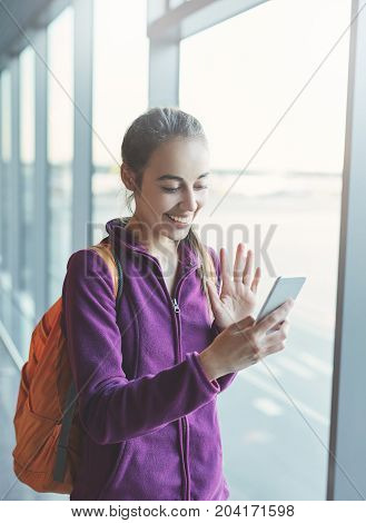 Girl at the airport window talking by phone