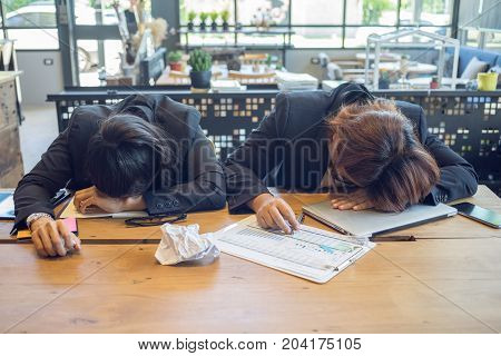 Businesswomen are sleeping on the desk in office after hard work.