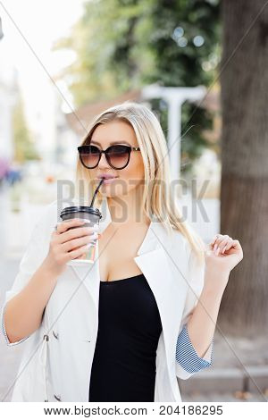 Relaxed Stylish Woman Drinking Coffee Outside On Urban Background