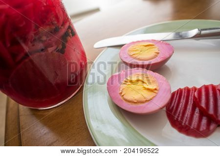 Sliced organic pickled beet eggs on wooden table