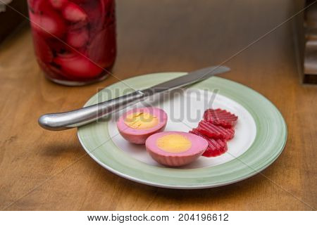 Sliced organic pickled beet eggs on wooden table