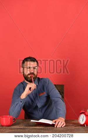 Man With Thoughtful Face Sits At Wooden Table