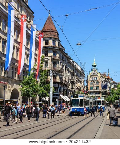 Zurich, Switzerland - 26 May, 2016: people and trams on Bahnhofstrasse street. Bahnhofstrasse is Zurich's main downtown street and one of the world's most expensive and exclusive shopping avenues.