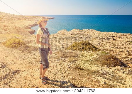 Young woman tourist in seascape picturesque view of Mediterranean Sea Cyprus Ayia Napa Cape Greco peninsula Kavo Greco national forest park