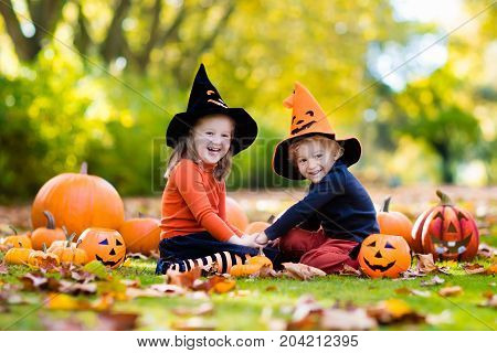 Kids With Pumpkins In Halloween Costumes