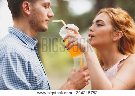 Close-up portrait photo of the girl, gives a drink to a guy. Lifestyle concept.