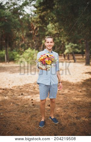 Full length photo of cute boy. with bright gift, standing in the forest. Lifestyle concept.