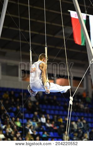 Male Gymnast Performing On Stationary Gymnastic Rings