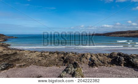 Achnahaird Bay rocks and sand on a beautiful day.