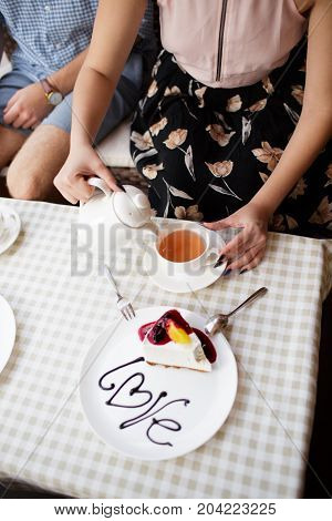 A young couple ordered a cheesecake in a cafe.