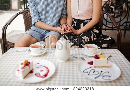 A young couple ordered a cheesecake in a cafe.