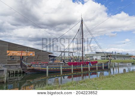 Roskilde Denmark - August 01 2015: replica of ancient boat and visitors outside the Vicking Ship Museum
