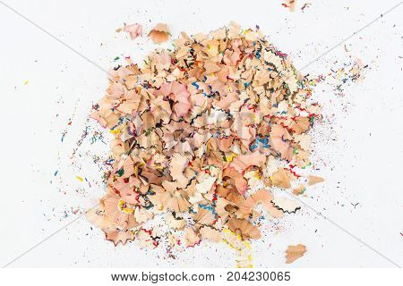 A bunch of shavings of colored pencils on light grey background