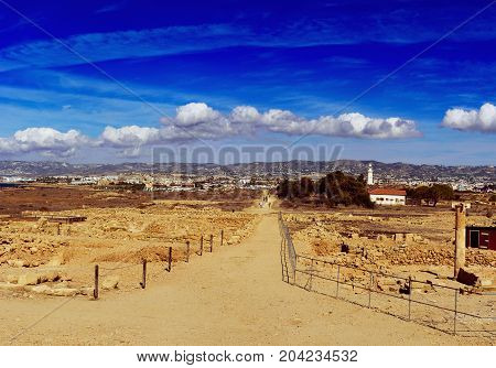Ancient ruins of Kourion city near Pathos and Limassol, Cyprus. Ruins and road under blue sky. Travel outdoor background