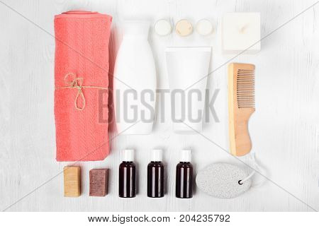 Towel cosmetics spa comb hair lotion on white wooden background isolation