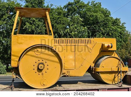 Old steamroller on a trailer vehicle in summer