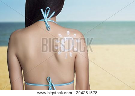 UV reflection skin after protection. Skin care concept. Woman applying sunscreen on her back with sea background. SPF sunblock protection concept. Travel vacation