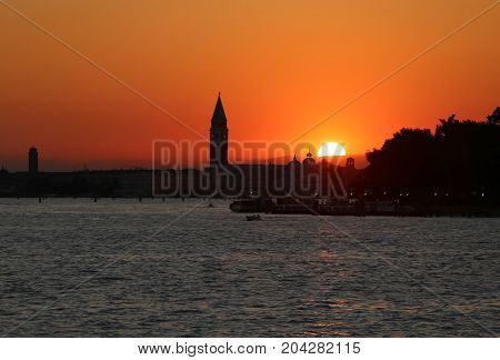 Sun At Sunset In Venice In Italy And The Campanile Of St. Mark