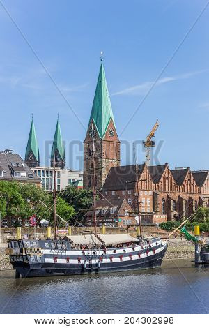 BREMEN, GERMANY - AUGUST 23, 2017: Historical ship and church along the river Weser in Bremen, Germany