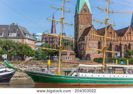 BREMEN, GERMANY - AUGUST 23, 2017: Historical ship and church along the river Weser in Bremen, Germany
