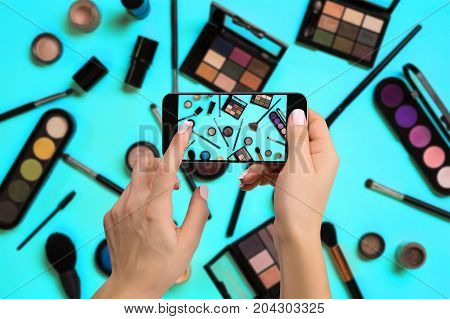 Young woman taking photo to cosmetics with cell phone or smartphone digital camera for post to sell online on the internet. Online business internet of things concept