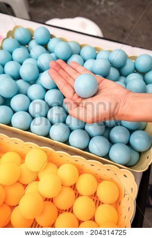 Woman hand holding one blue ping-pong balls.