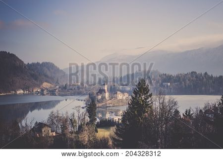 The Lake Bled lies in picturesque environment surrounded by hills and forest with medieval castle stands and several buildings on small island, Gorgeous view of Bled castle reflect on Lake Bled in the Julian alps seen from Little Osojnica Hill with many g