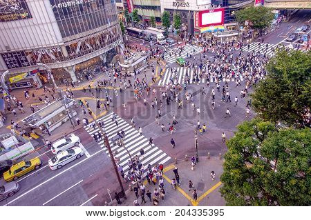 TOKYO, JAPAN JUNE 28 - 2017: Top view of crowd of people crossing in Shibuya street, one of the busiest crosswalks in the world, in the Ginza District in Tokyo, Japan.