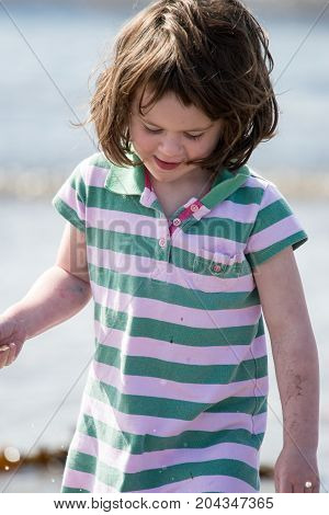 View of Young little girl on beach playing in the surf