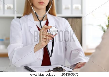 Unknown female doctor with a stethoscope in the hands. Physician is redy to exemine a patient. Medicine and health care conept