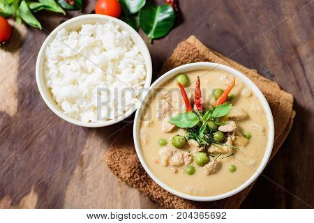 Thai food (Phanaeng curry), red curry with pork and cooked rice in a bowl on wooden background