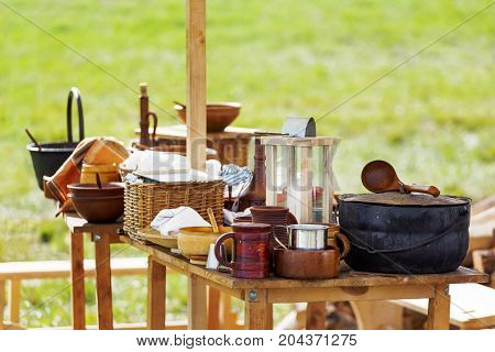 Wooden table with old fashioned wooden and earthenware crockery. Historical reconstruction of 19 century.