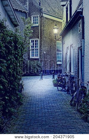 Typical Dutch brick houses in Holland at night. Street View with bikes parked in the historical center of Amersfoort in the Netherlands