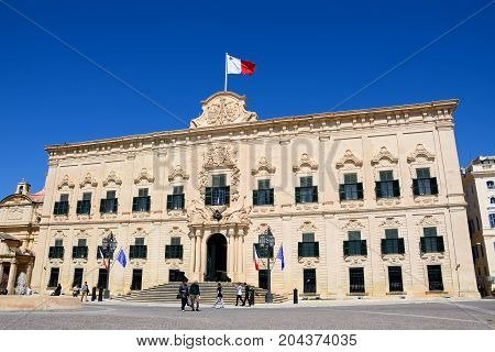 VALLETTA, MALTA - MARCH 30, 2017 - View of the Auberge de Castille in Castille Square with tourists enjoying the setting Valletta Malta Europe, March 30, 2017.