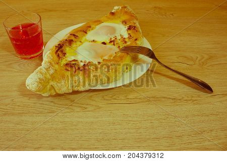 Adjarian khachapuri on a on a plate. Open pie with cheese in the shape of the boat. Delicious homemade khachapuri in Adjarian - Retro color