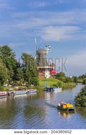GREETSIEL, GERMANY - JULY 18, 2017: Tourists in a paddle boat on the river in Greetsiel, Germany