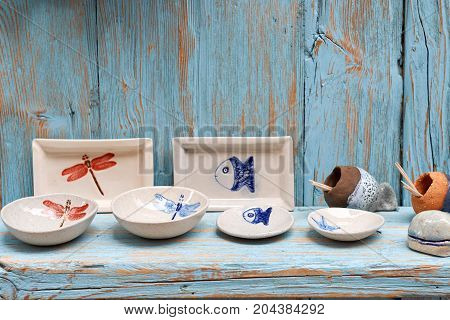 Simple rustic kitchenware against blue wooden wall: Pretty ceramic dishes