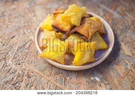 Deep fried wonton or fried dumplings cuisine on wood plate