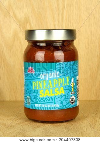 RIVER FALLS,WISCONSIN-SEPTEMBER 16,2017: A jar of Casa Mamita brand pineapple salsa with a wood background.