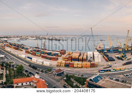 ALBANIA DURRES - September 22 2015: Panorama of the port of Durres at sunset. Unloading of the tanker by cargo cranes. A platform for storing sea freight containers. Cruise liners and cargo ships are moored in the port