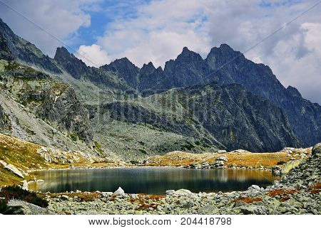 High Tatras in Slovakia. Monumental peaks. Summer scenic landscape mountain view. Alpine trail. Prostredny hrot and Starolesnianske tarn in Big cold valley.