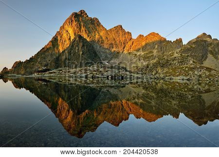 Sunrise in High Tatras in Slovakia. Monumental peak Prostredny hrot. Summer scenic landscape mountain view. Alpine trail. Small cold valley with Prostredne Spisske tarn.