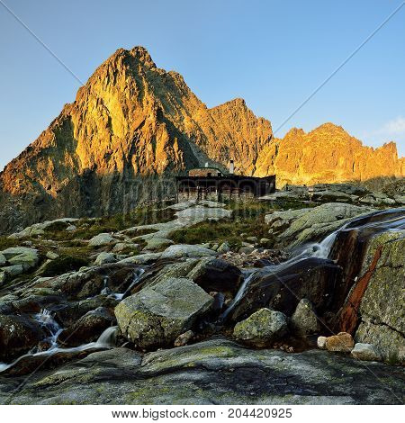 Sunrise in High Tatras in Slovakia. Monumental peak Prostredny hrot. Summer scenic landscape mountain view. Alpine trail. Small cold valley with Tery cottage.