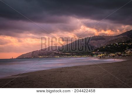 Sunset over Castelldefels beach in summer with clouds