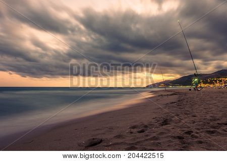 Sunset over Castelldefels beach in summer with clouds