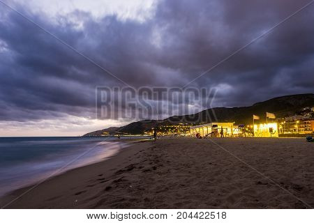 Sunset over Castelldefels beach in summer with clouds