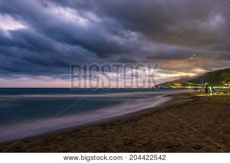 Sunset over Castelldefels beach in summer with clouds